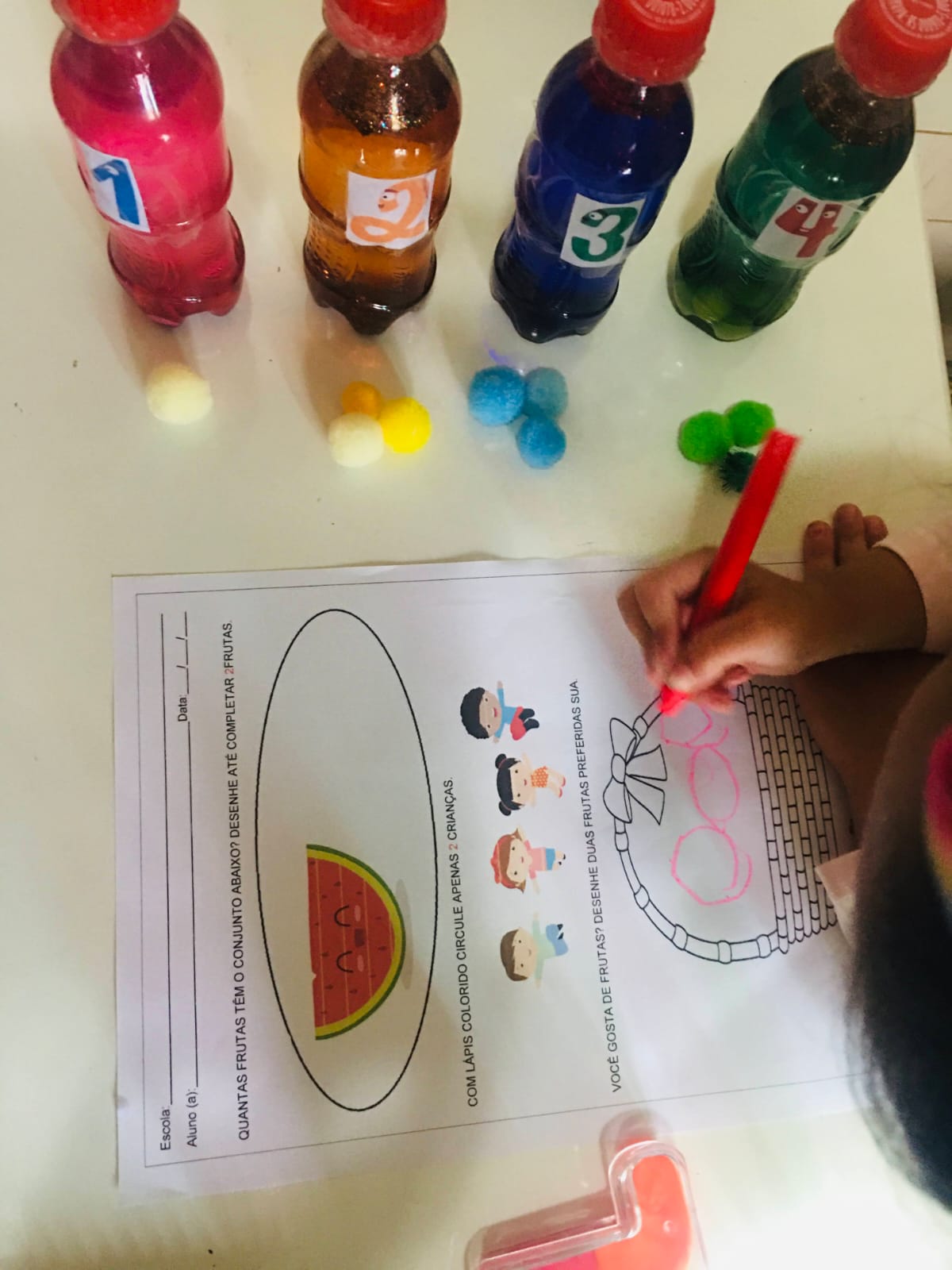 Criança desenhando frutas em uma atividade de contagem e coordenação motora